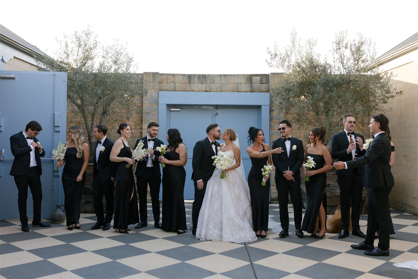 A black-tie bridal party lined up on the checkerboard