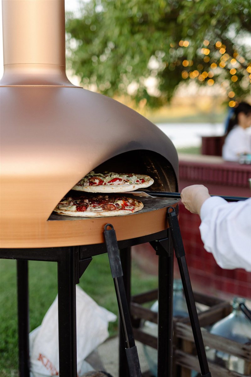 Pizza coming out of the wood oven on welcome night