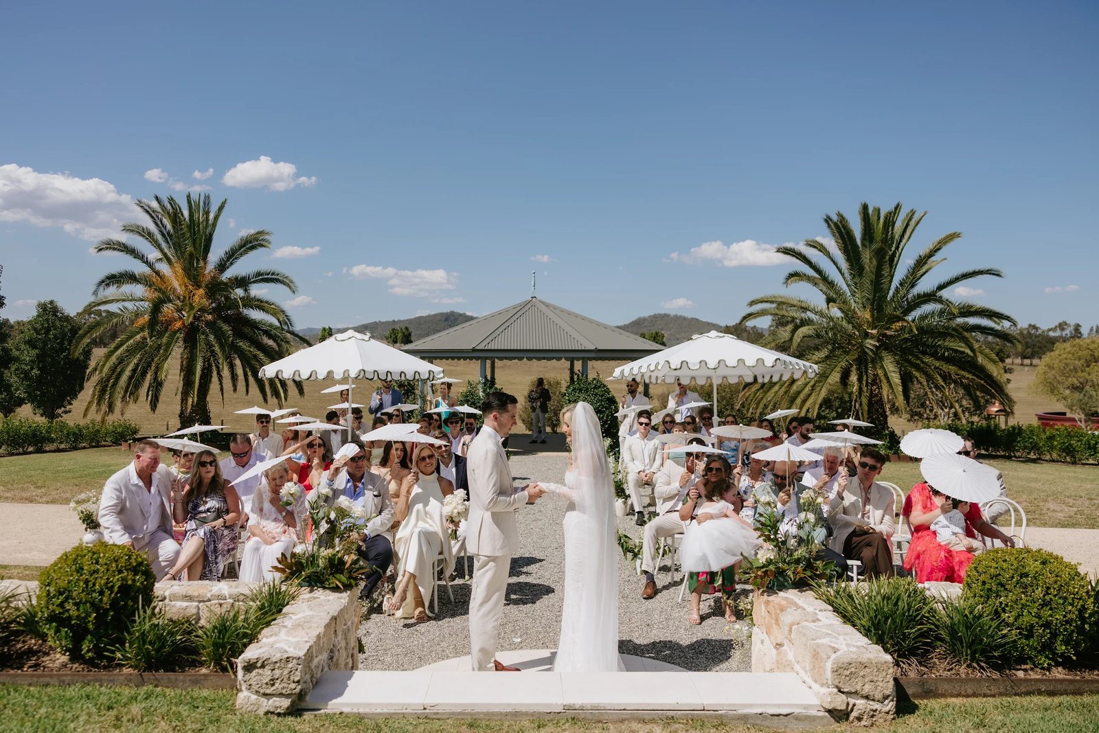 Guests under white umbrellas in the piazza garden